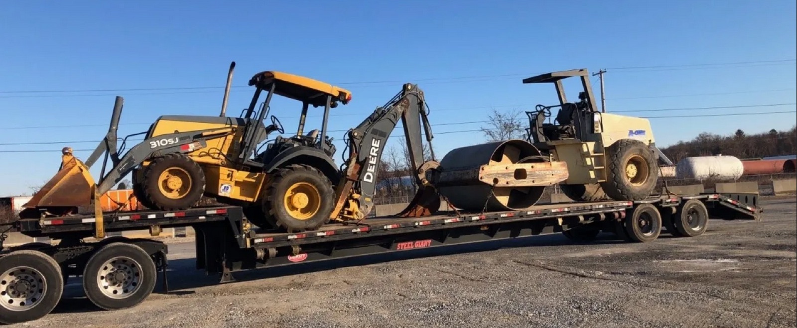 Backhoe and roller compactor loaded on a stepdeck