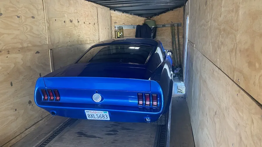 Classic Ford Mustang loaded inside an enclosed trailer