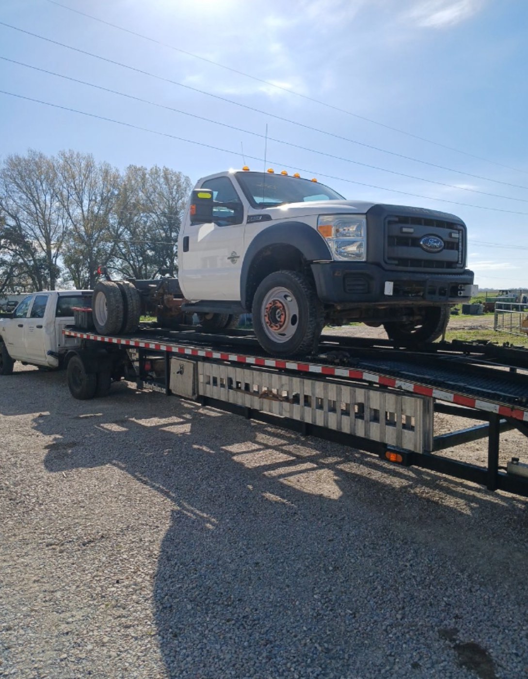 Ford F-550 chassis loaded on a flatbed trailer