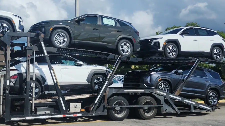 Five new SUVs loaded on a mini car hauler for a dealership