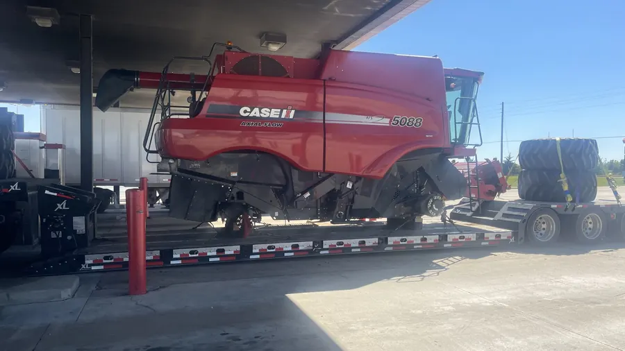 Case IH agricultural harvester loaded on a lowboy trailer