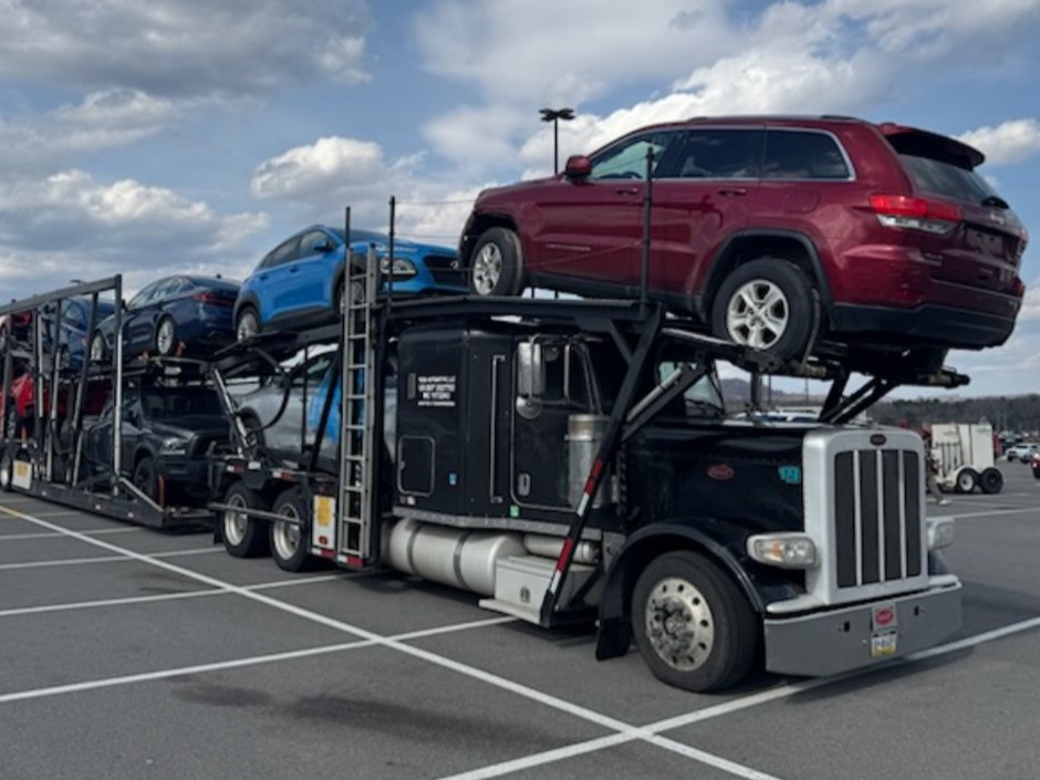 Peterbilt car hauler loaded with a Jeep Grand Cherokee and other vehicles